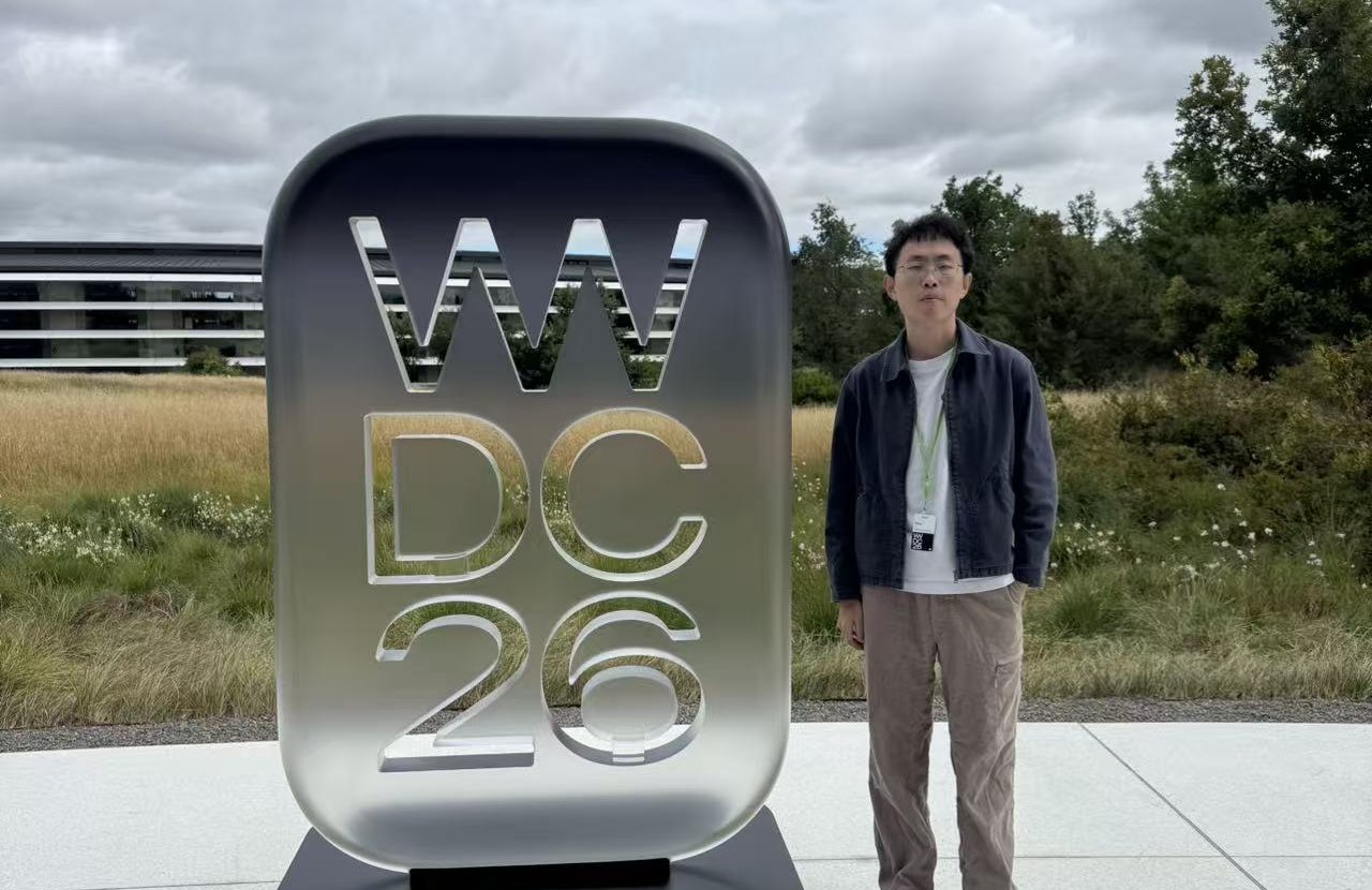 Evan 李同学在 WWDC 26 标识前的照片
